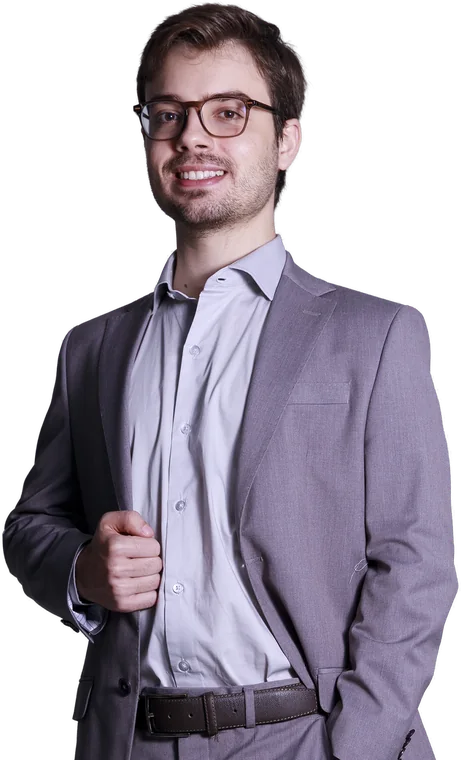 Dr. Caíque Dias, de terno cinza e óculos, sorrindo